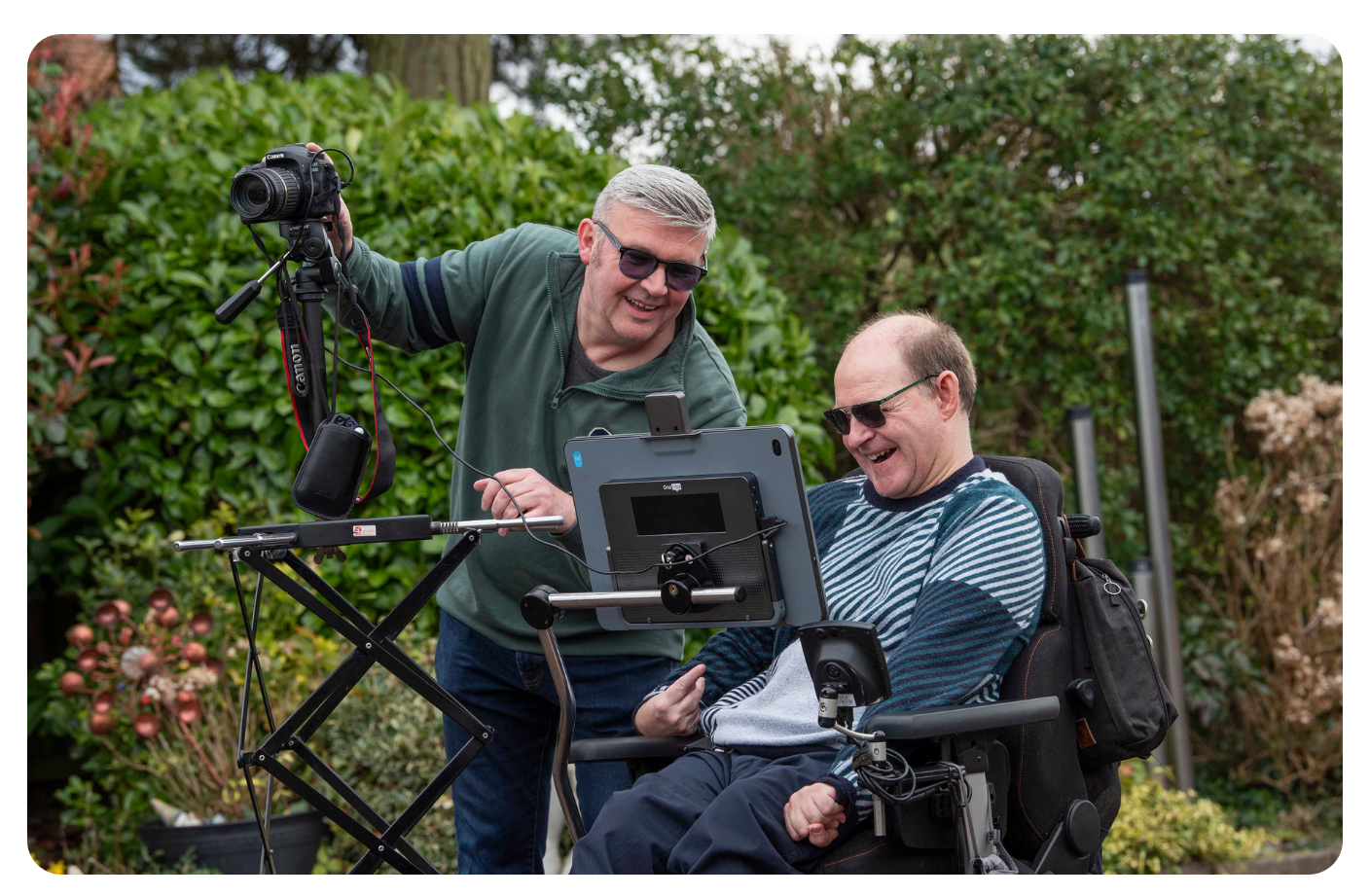 Richard with another man taking photographs using Smart Shooter software, controlling his Canon camera through the Grid Pad’s USB ports, looking happy.