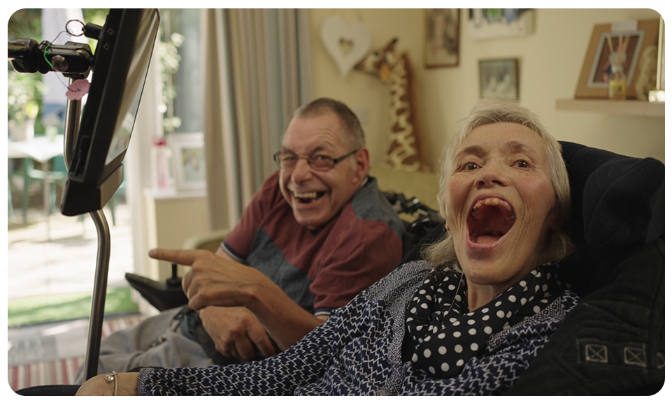 Claire and her husband Les in their care home. Claire uses a Grid Pad 12 to communicate and control technology around her home.