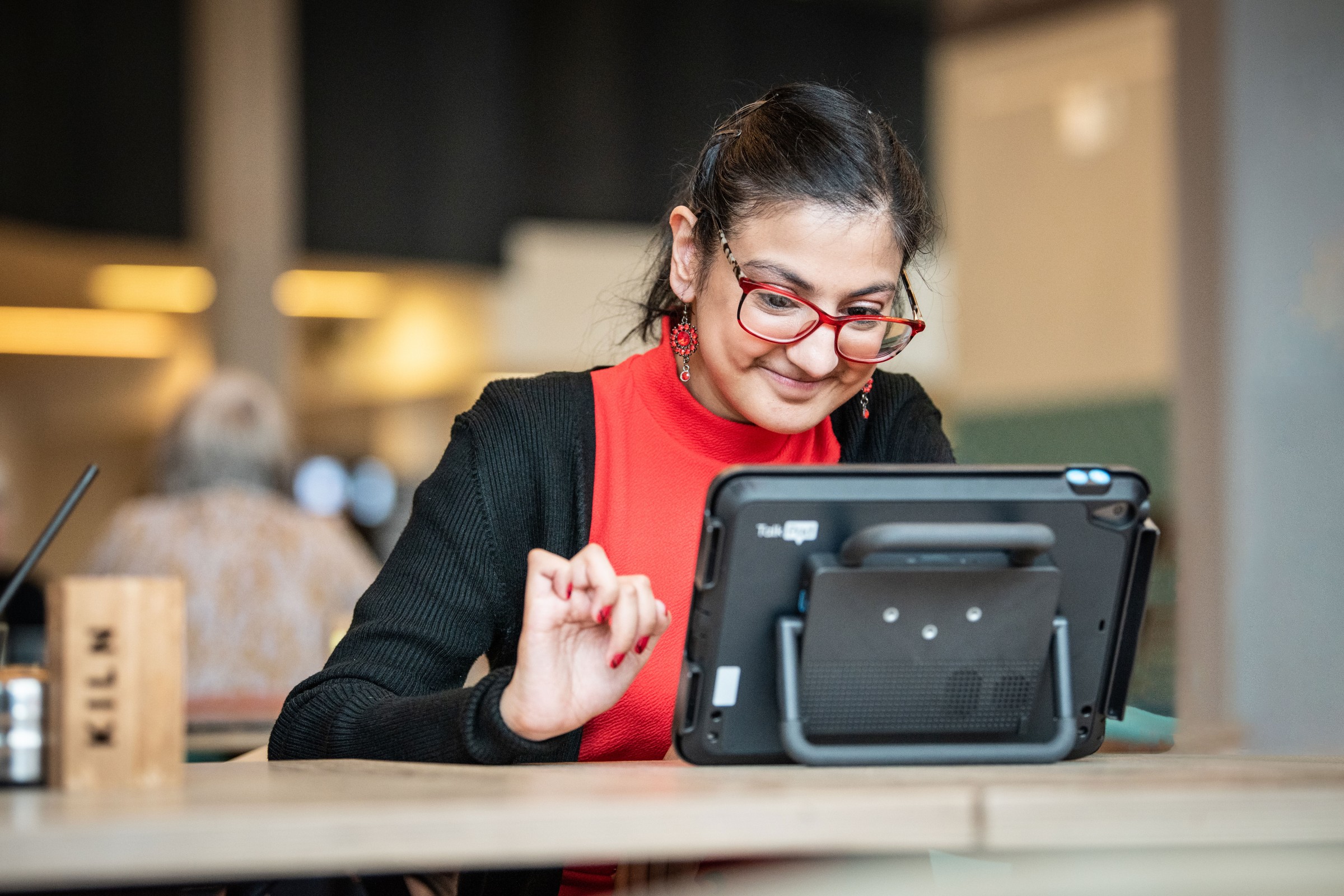 Sufina uses the 10-inch Talk Pad device in a cafe.