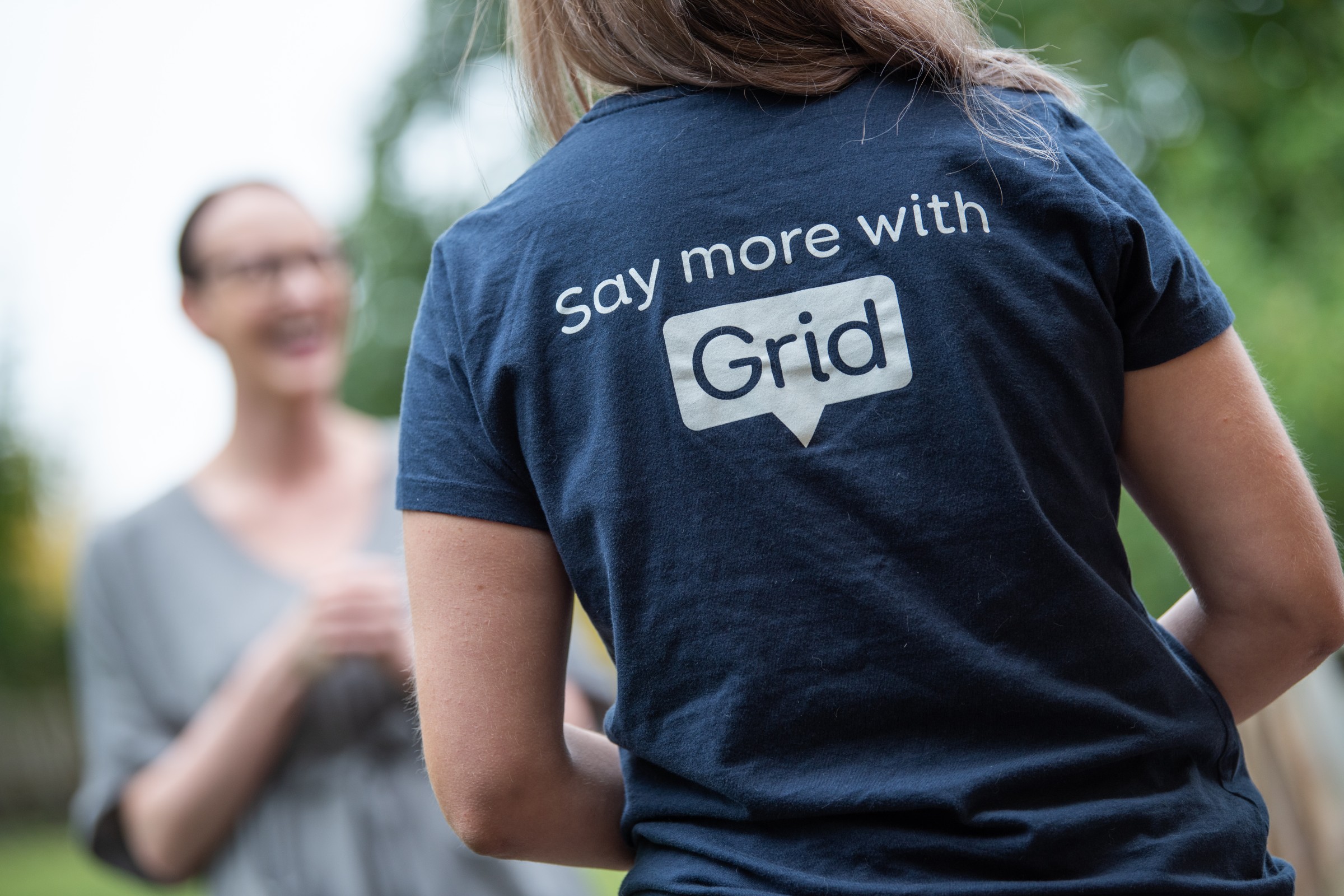 A photo of a person wearing a Smartbox T shirt, with the text 'Say more with Grid'