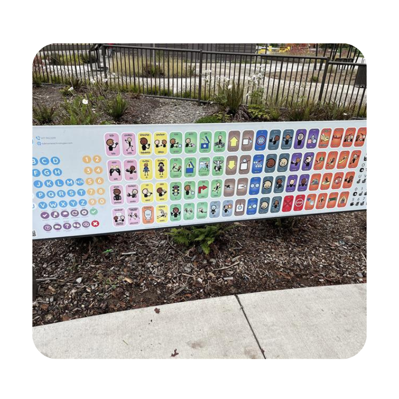 A colorful AAC low tech board hung in a park