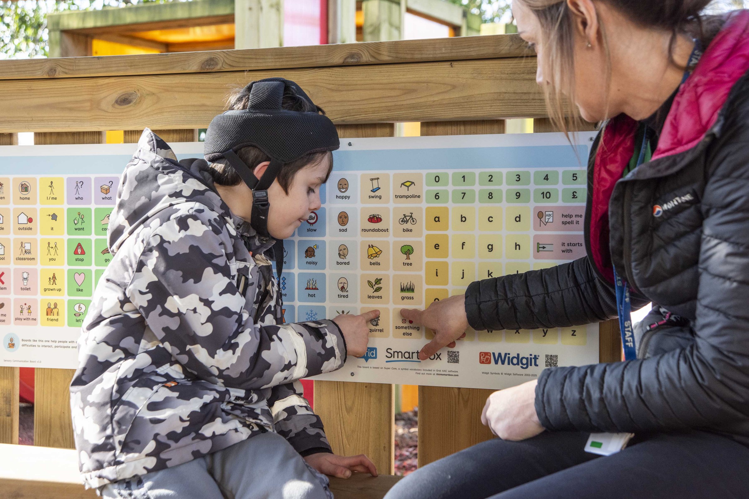 A young child and a communication partner using the Smartbox communication board.