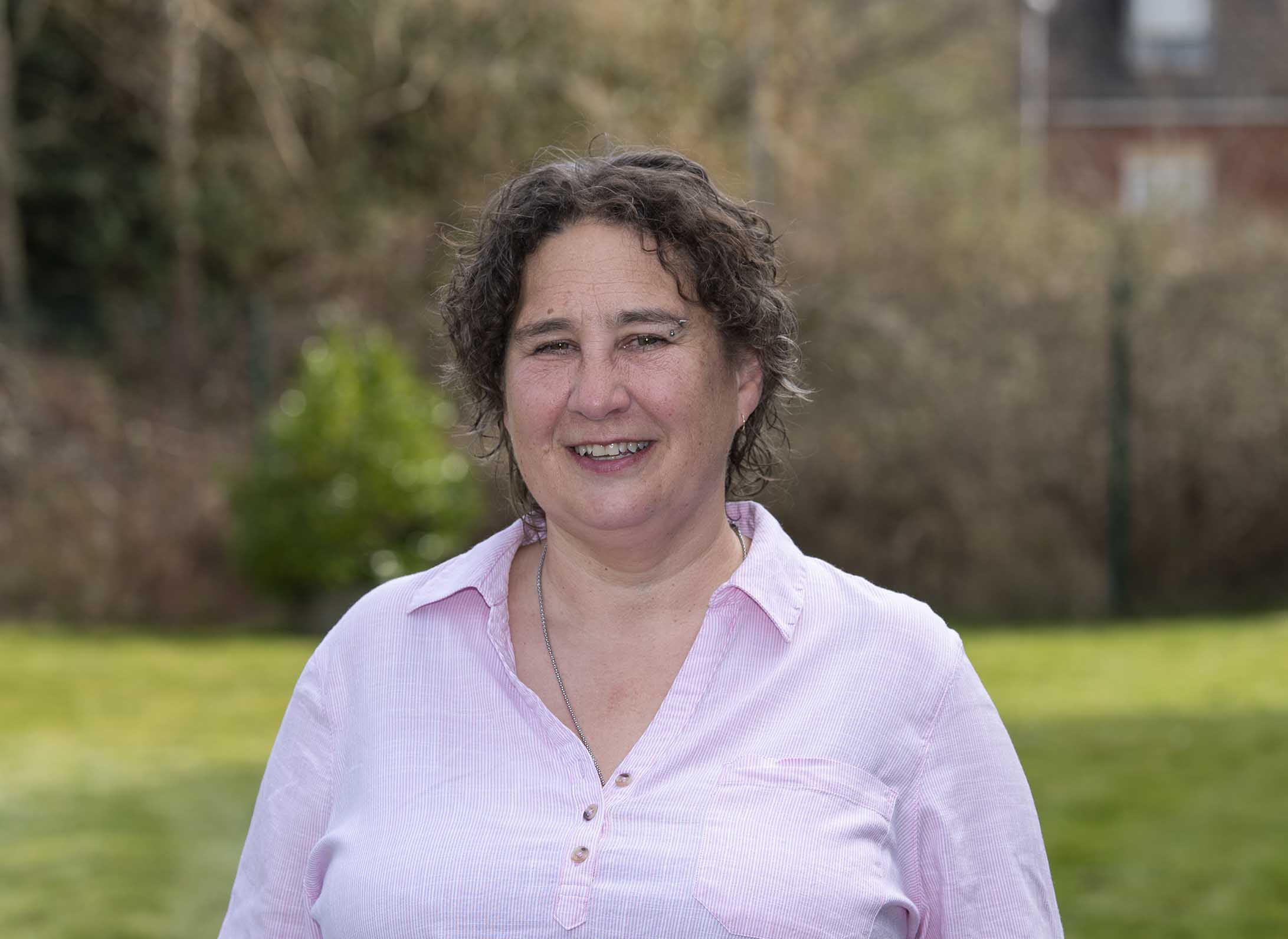 Saffron, an AAC specialist teacher, smiling while in the park.