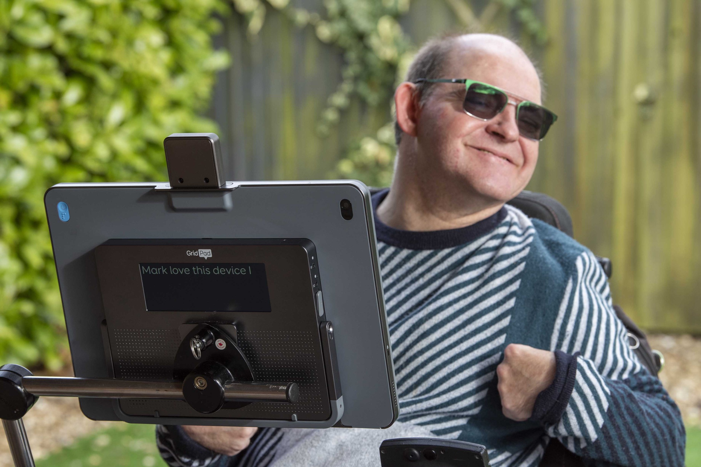 Mark smiling while using his Grid Pad 16, with 'Mark loves this device' written on the back.
